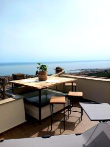 - une table sur un balcon avec vue sur l'océan dans l'établissement Hostdomus - Le Vigne sul Mare, à Pietra Ligure