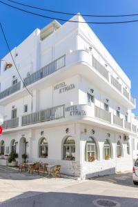 un bâtiment blanc avec des tables devant lui dans l'établissement Kymata Hotel, à Naxos Chora