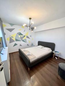 ein Schlafzimmer mit einem Bett und einem Wandgemälde in der Unterkunft Old Town View- Central Apartment in Târgovişte