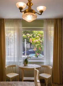 d'une salle à manger avec une table et une fenêtre. dans l'établissement Família Vendégház, à Szeged
