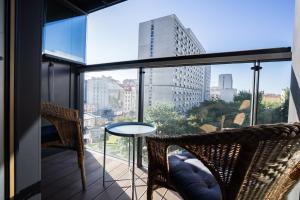 a balcony with chairs and a table and a view of a city at VipWarsawApartments Sapphire Mennica Residence in Warsaw