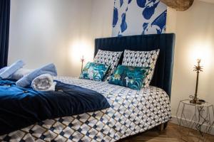 een slaapkamer met een bed met blauwe en witte kussens bij Suite Saphir - Jacuzzi & Sauna in Saint-Étienne