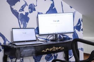 a desk with a laptop and a monitor on it at Suite Saphir - Jacuzzi & Sauna in Saint-Étienne