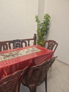 a red table with four chairs and a plant at Perivale in Moratuwa