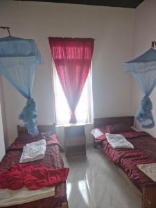 two beds in a room with a window at Perivale in Moratuwa