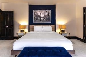 1 dormitorio con 1 cama blanca grande y 2 lámparas en Main Street Oasis - with Parking en Covington