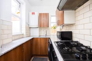 a kitchen with a stove top oven next to a window at 1 Bedroom Flat in Bromley in Hither Green