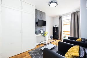 a living room with two black couches and a tv at 1 Bedroom Flat in Bromley in Hither Green