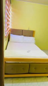 1 cama pequeña con sábanas blancas y almohadas en una habitación en RCA Transient house in San Jose del Monte, en Muzon