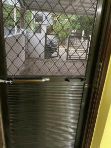 una puerta con una ventana cerrada con una valla en RCA Transient house in San Jose del Monte, en Muzon