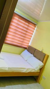 - un petit lit dans une chambre avec fenêtre dans l'établissement RCA Transient house in San Jose del Monte, à Muzon