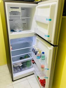 - un réfrigérateur ouvert avec une porte ouverte et de la nourriture à l'intérieur dans l'établissement RCA Transient house in San Jose del Monte, à Muzon