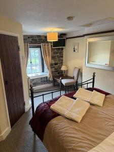 ein Schlafzimmer mit einem Bett mit zwei Kissen darauf in der Unterkunft Superbly appointed 300 year old stone cottage in Bakewell