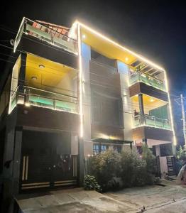 Bhoomiputra Mansion في ميسور: عمارة سكنية كبيرة مع موقف سيارات في الليل