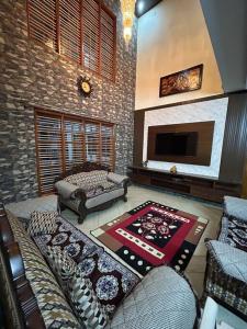 Bhoomiputra Mansion في ميسور: غرفة معيشة مع أريكة وتلفزيون