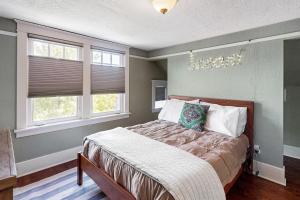 a bedroom with a bed and two windows at West Woodland Wonder in Seattle