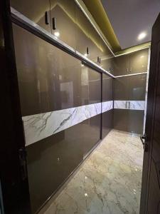 Bhoomiputra Mansion في ميسور: حمام بجدران زجاجية وأرضية رخامية