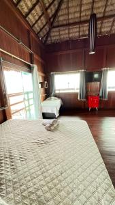 Pousada Amor Do Arpoador في توتويا: غرفة نوم بسرير كبير في غرفة بها نوافذ