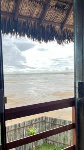 a view of the beach from the window of a hut at Pousada Amor Do Arpoador in Tutóia