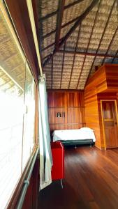 a bedroom with a bed and a red chair in a room at Pousada Amor Do Arpoador in Tutóia