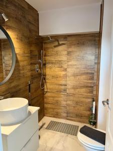 La salle de bains est pourvue de murs en bois et d'un lavabo. dans l'établissement Old Town View- Central Apartment, à Târgovişte