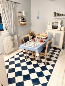 una cocina con mesa y sillas en un suelo a cuadros en Studio avec jardin clos et wifi a Thilouze, en Thilouze