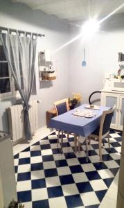 una cocina con mesa azul y sillas en un suelo a cuadros en Studio avec jardin clos et wifi a Thilouze, en Thilouze