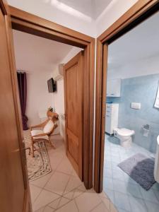 ein Badezimmer mit einem WC und einer Holztür in der Unterkunft Nido d'amore ad Arzachena in Arzachena