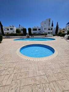 une petite piscine dans une cour avec des bâtiments en arrière-plan dans l'établissement Marina Gardens, delightful 2 bedroom apartment, à Paphos