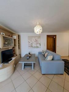 ein Wohnzimmer mit einem blauen Sofa und einem Tisch in der Unterkunft Nido d'amore ad Arzachena in Arzachena