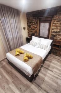 a bedroom with a bed with yellow shoes on it at O Lar de Alba in A Rúa
