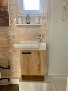 ein Bad mit einem weißen Waschbecken und einem Fenster in der Unterkunft Tinyhouse Bamberg in Pettstadt