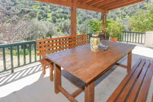 a wooden picnic table on a balcony with a view at Country house in Limnionas in Ayía Kiriakí