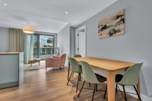 a dining room with a wooden table and chairs at Spacious Two Bedroom Apartment at Wembley Park in London