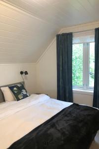 1 dormitorio con cama y ventana en Store Ringheim Apartment - Villa Solberg, en Vossevangen