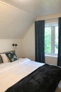 a bedroom with a bed and a window at Store Ringheim Apartment - Villa Solberg in Vossevangen