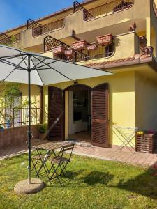 stół i parasol przed domem w obiekcie La casina delle Sorgentelle w mieście Bagni San Filippo