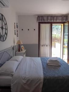 1 dormitorio con 1 cama y reloj en la pared en La casina delle Sorgentelle en Bagni San Filippo