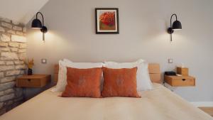 a bedroom with a bed with orange and white pillows at Maisons Vaudésir - Centre, Clim, Bain Nordique, 5 Étoiles in Chablis +19 photos