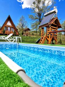 a swimming pool in the grass next to a house at Stelele Coziei in Valcea