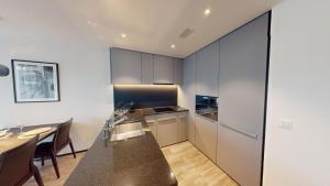 a kitchen with black cabinets and a table and a dining room at block E, 13 Sonnentalstrasse in Zurich