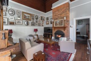 a living room with a couch and a fireplace at Derby Bank House- Heritage listed two bedroom old school B&B suite or a self contained cabin in Derby