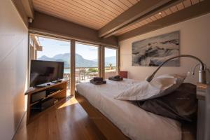 una camera con un letto e una grande finestra di Savoielac - Lac d'Annecy - Talloires - Vue panoramique : Villa Egalité Golf a Talloires
