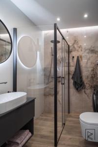 a bathroom with a shower and a toilet and a sink at Apartament White Glove Deluxe Stara Warszawska in Olsztyn