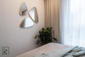 a bedroom with three mirrors on the wall at Apartament White Glove Deluxe Stara Warszawska in Olsztyn