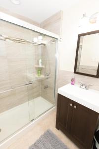 a bathroom with a shower and a sink and a mirror at Bright & Spacious 2-bed near NYC in Jersey City