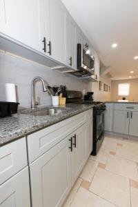 a kitchen with white cabinets and a sink at Bright & Spacious 2-bed near NYC in Jersey City