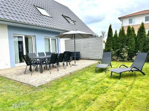 a patio with a table and chairs and an umbrella at 1310 - Haus Greta in Dahme
