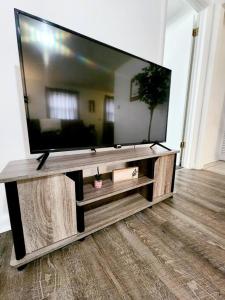 a large flat screen tv sitting on a entertainment center at Dorothy - The Hamilton Suites in Hamilton