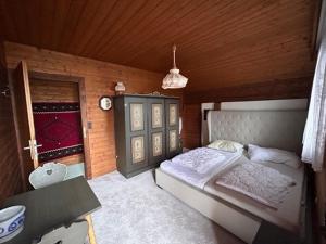 ein Schlafzimmer mit einem Bett und einer Holzwand in der Unterkunft Sweet Home Klippitztörl in Bad Sankt Leonhard im Lavanttal